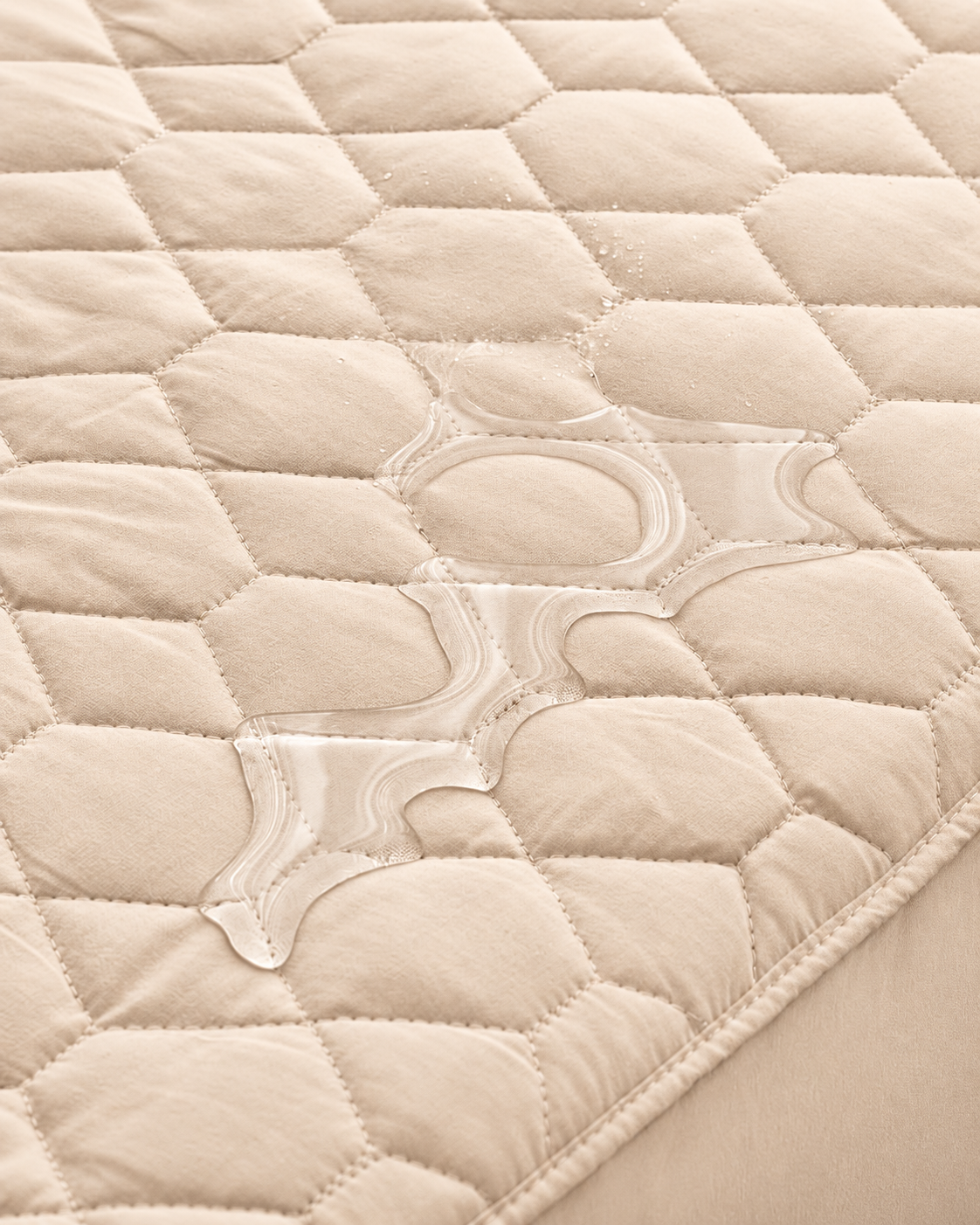 Beige quilted mattress protector – water close-up