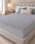 Grey Terry Mattress Protector fitted on a bed in a neutral bedroom