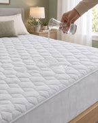 Water poured onto grey quilted mattress protector